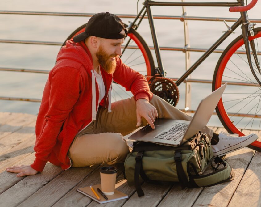 handsome bearded man traveling with bicycle working online