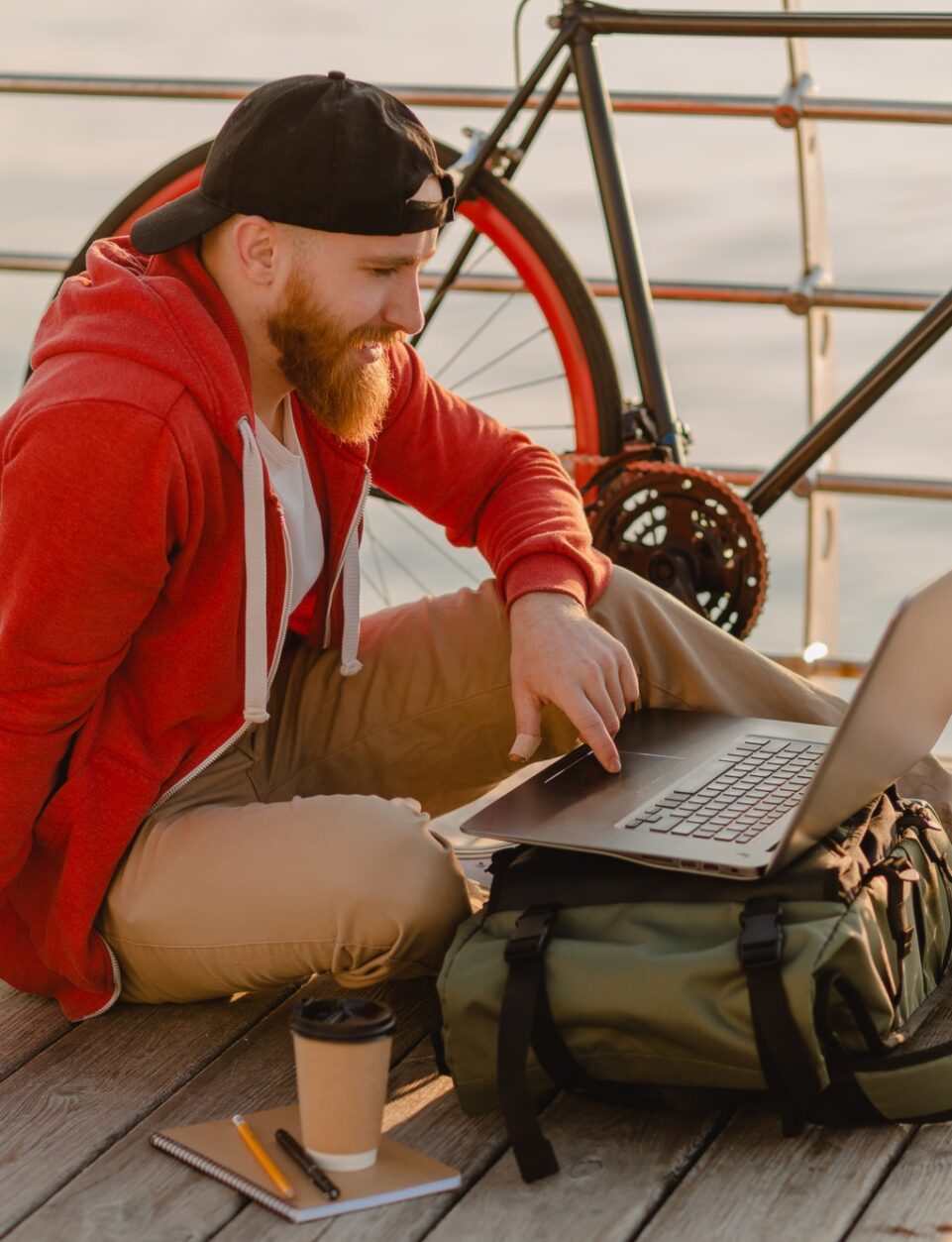 handsome bearded man traveling with bicycle working online