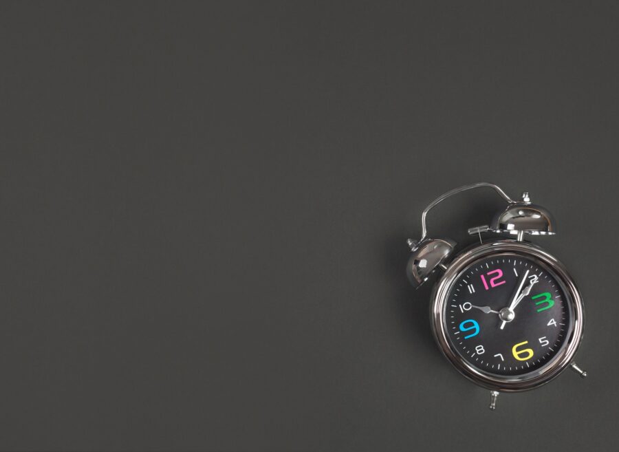Metal antique alarm clock on black background with space for text. Back to school concept.